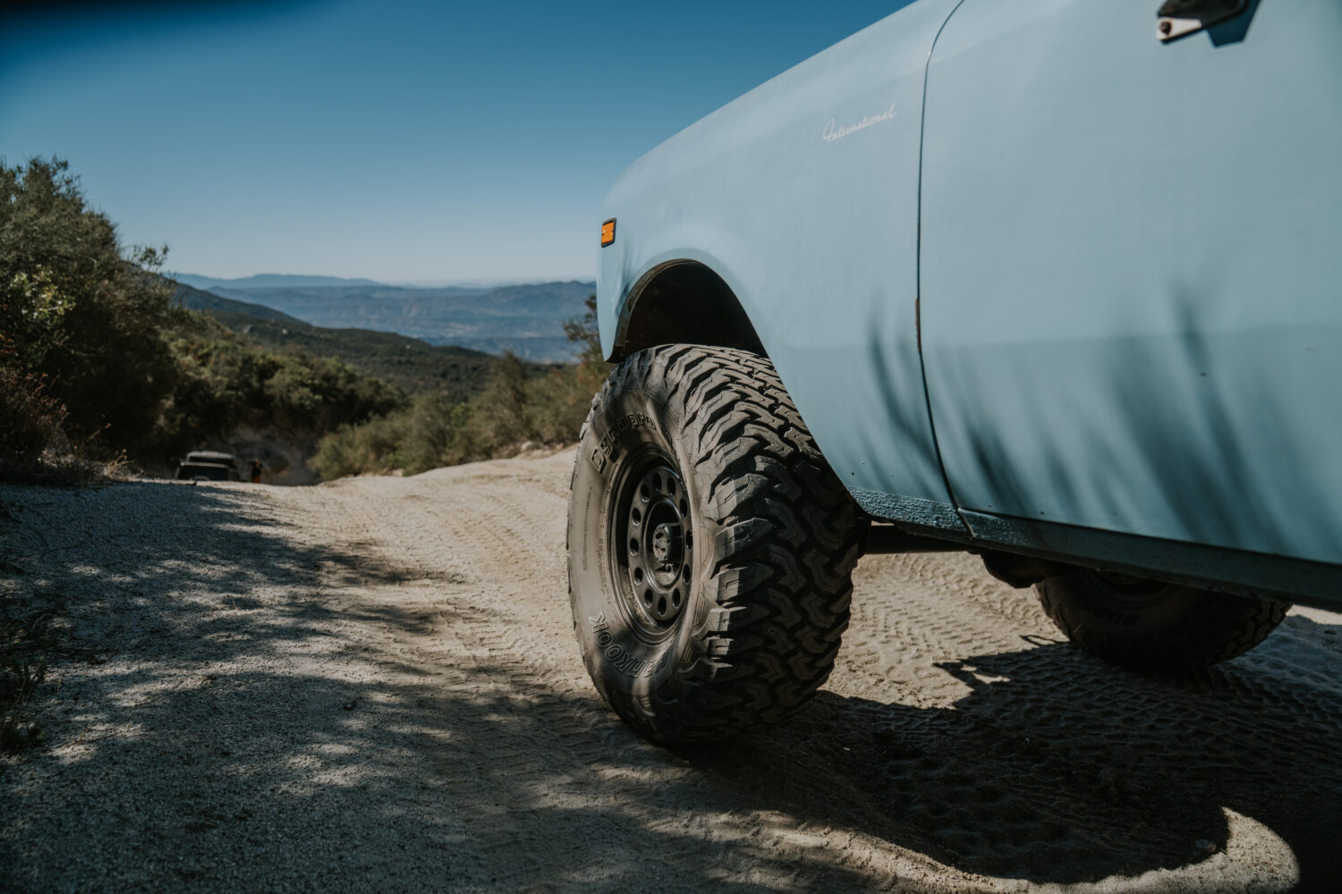 The test vehicles parked at a high elevation overlook with a vast mountain valley in the background.