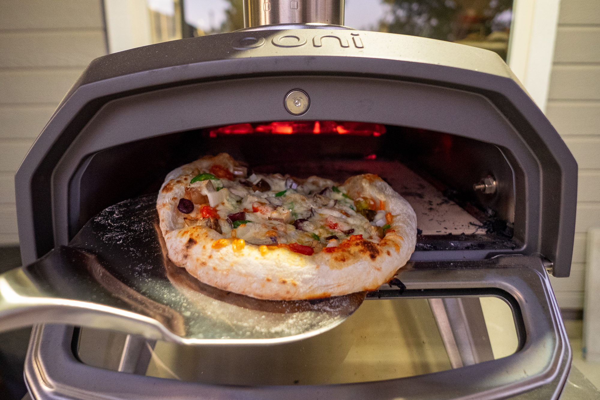 A Neapolitan-style pizza with charred crust inside an Ooni Karu oven fueled by wood.