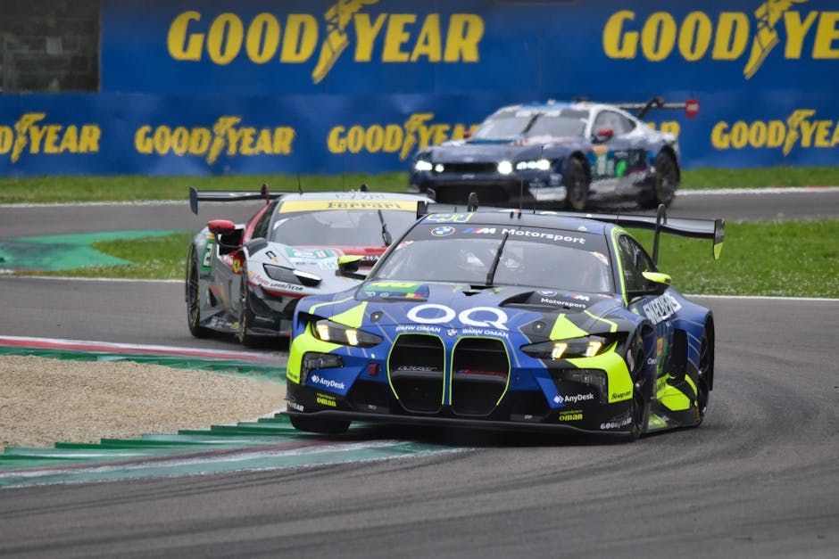 Action shot of professional race cars competing on a track during a motorsport event.