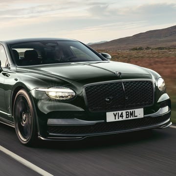 A luxury performance sedan driving on a scenic road.