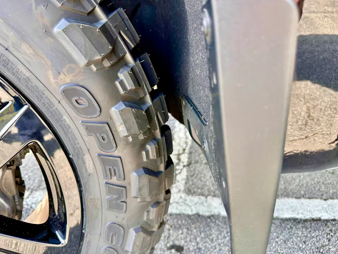 Front wheel well of a Silverado showing the clearance of Toyo 275/65R20 tires at a full steering turn.