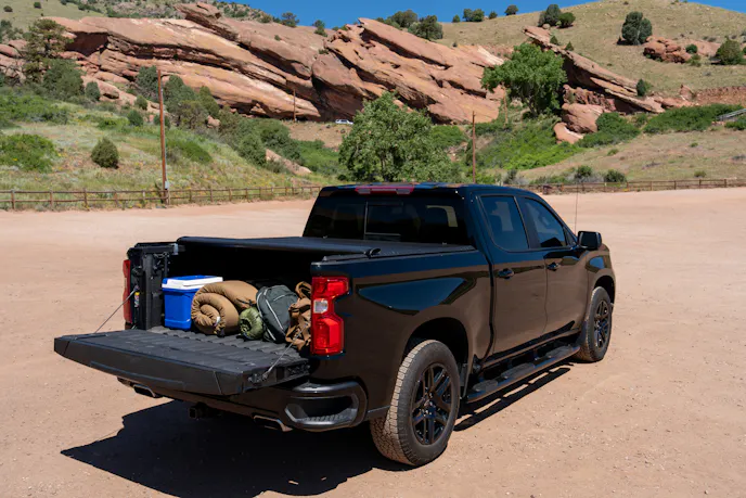 A tri-fold tonneau cover partially folded back on the bed of a pickup truck.