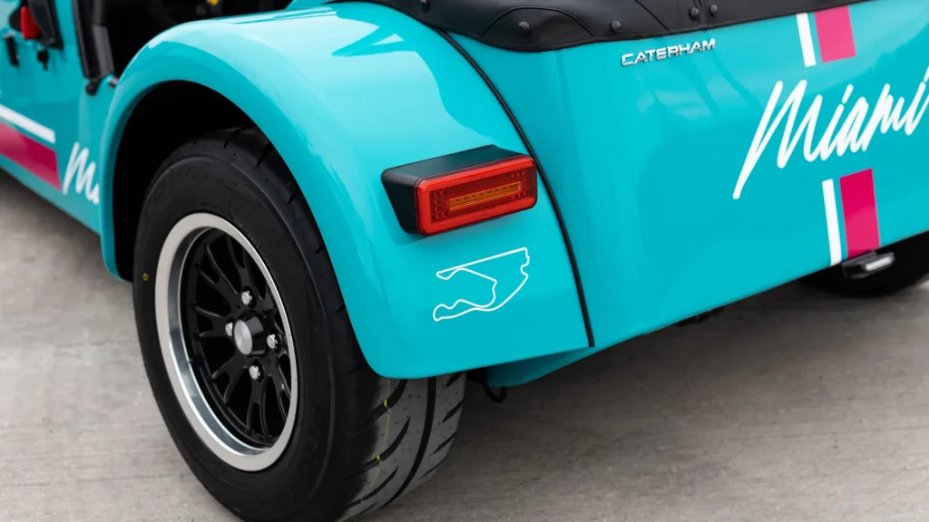 Rear view of a Caterham Seven showing pink decals and the Miami F1 track map.