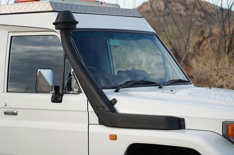 A black raised air intake snorkel mounted on the A-pillar of a Toyota 4x4.