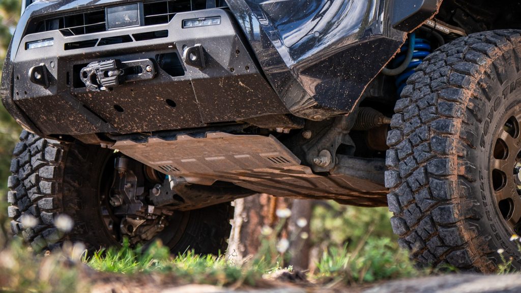 A truck climbing over a rocky ledge using Toyo R/T Pro tires.