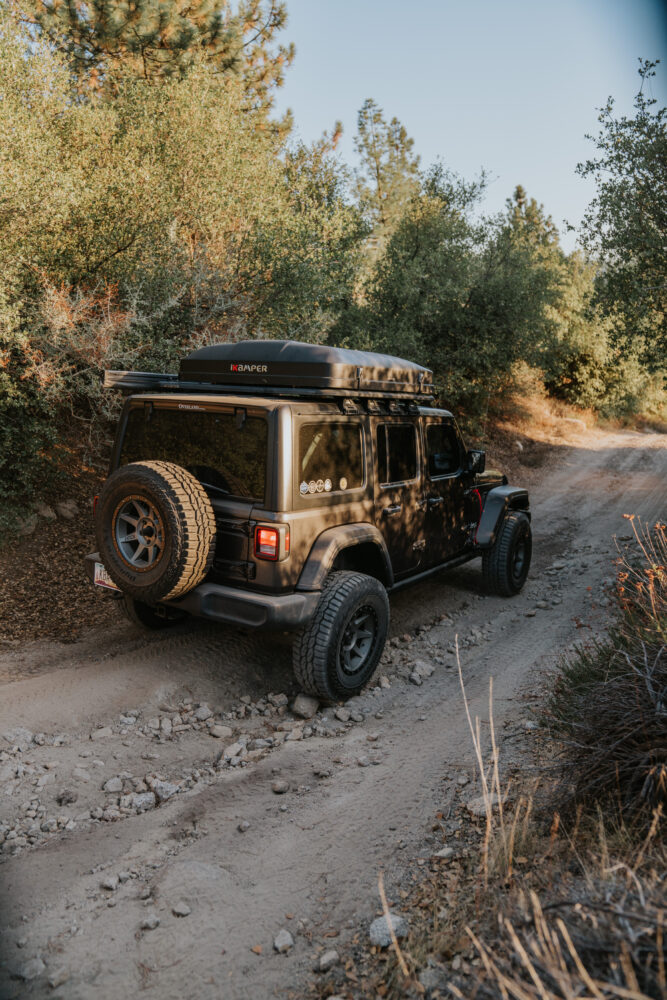 Close-up of a vintage Scout crawling over large rock slabs in the mountains.