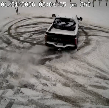 A white truck performing a drift on a snowy surface to demonstrate traction and control.