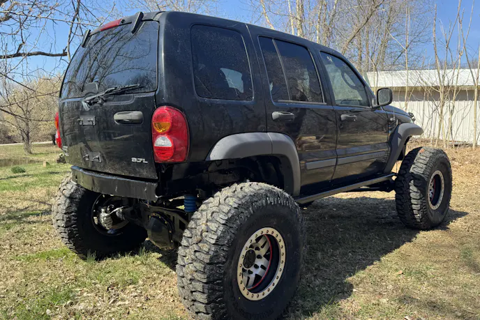 Rear view of a Jeep Liberty showing custom frame work and off-road modifications.