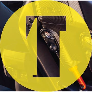 Close-up of high-performance car interior featuring carbon fiber and analog-style gauges.