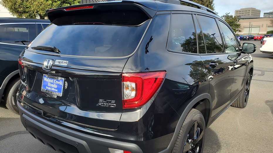 A dark-colored Honda Passport SUV parked in an outdoor setting.