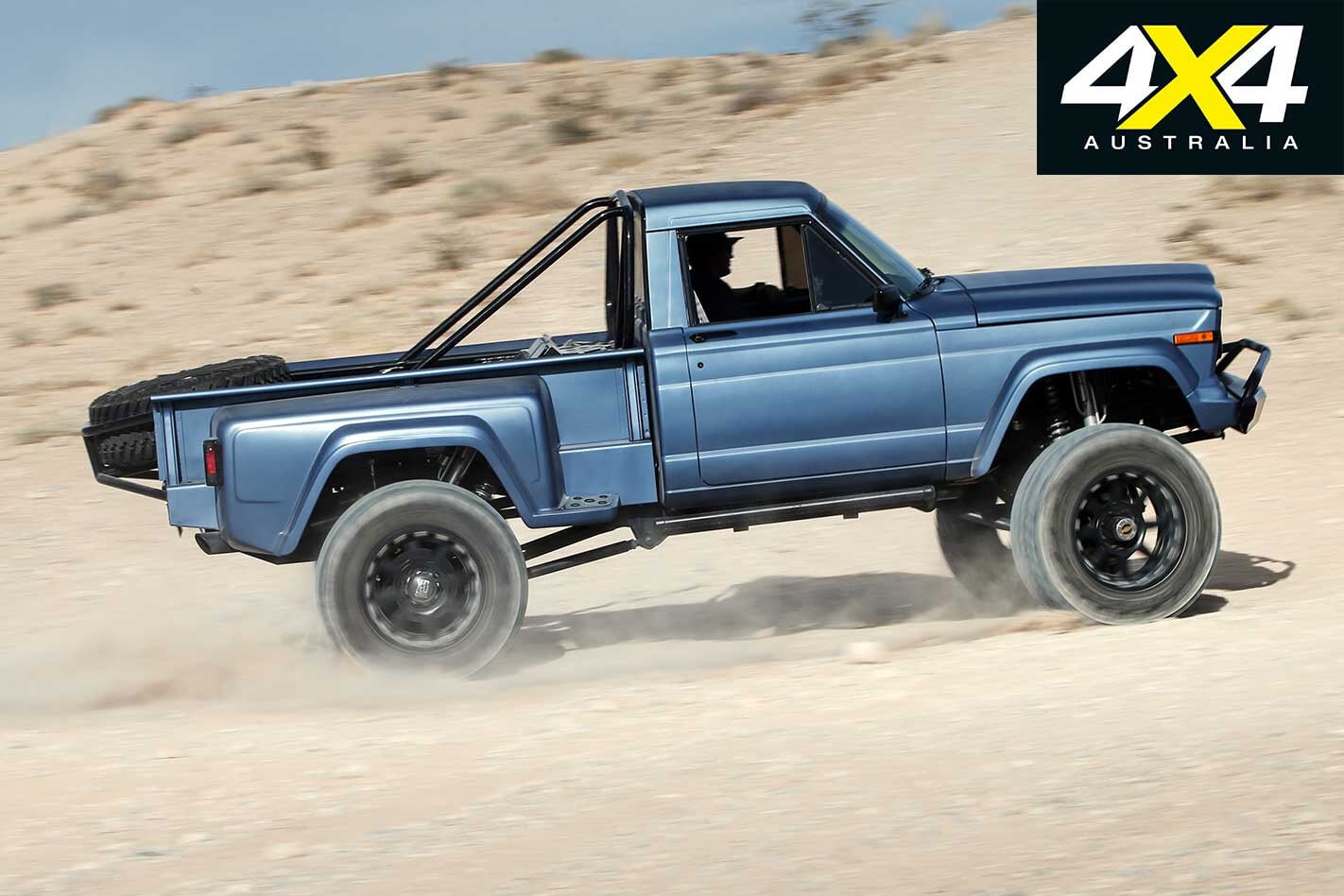 Side profile of a blue 1984 Jeep J10 with 37-inch Nitto Mud Grappler tires and custom suspension.