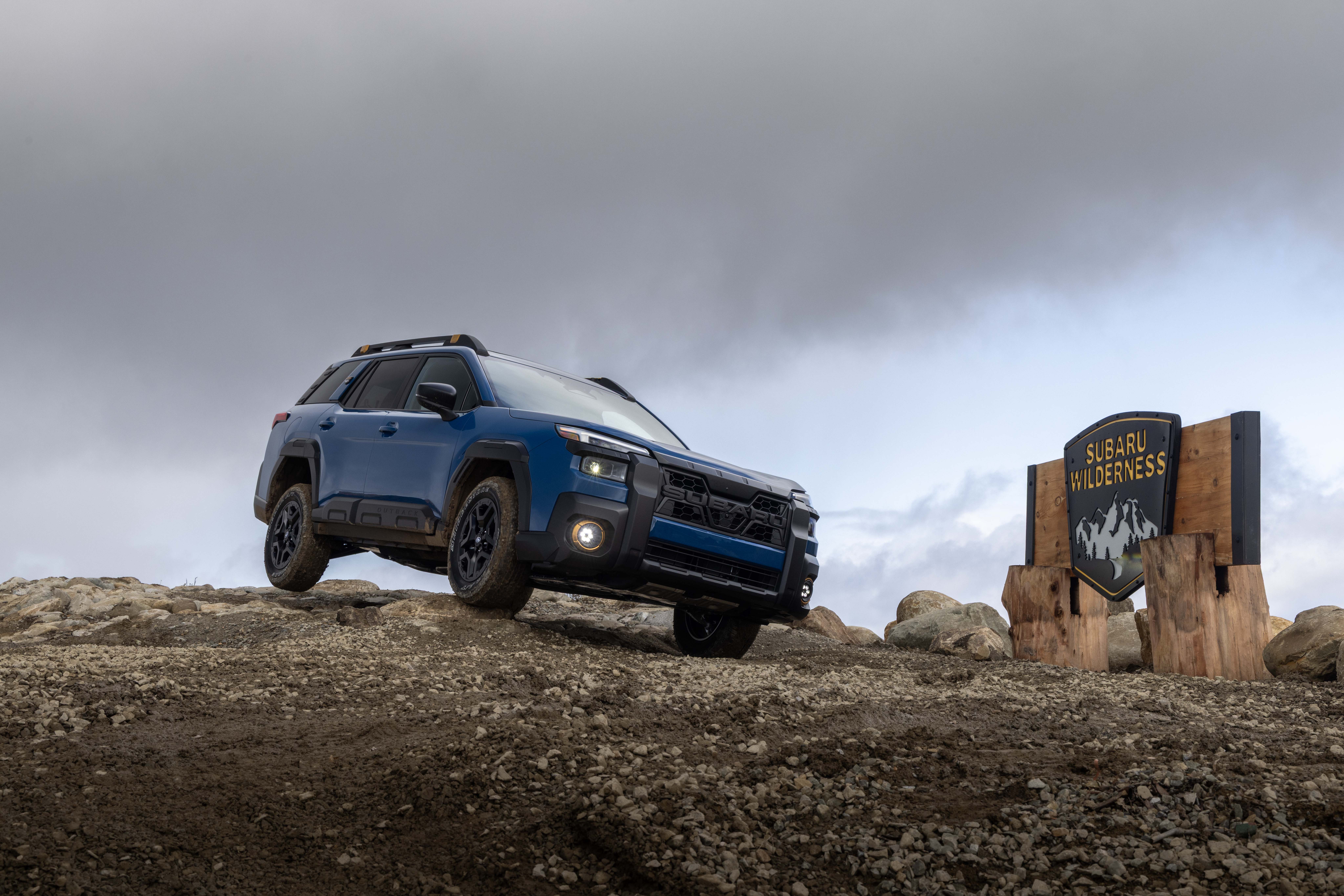 The 2026 Subaru Outback driving through a wooded area.