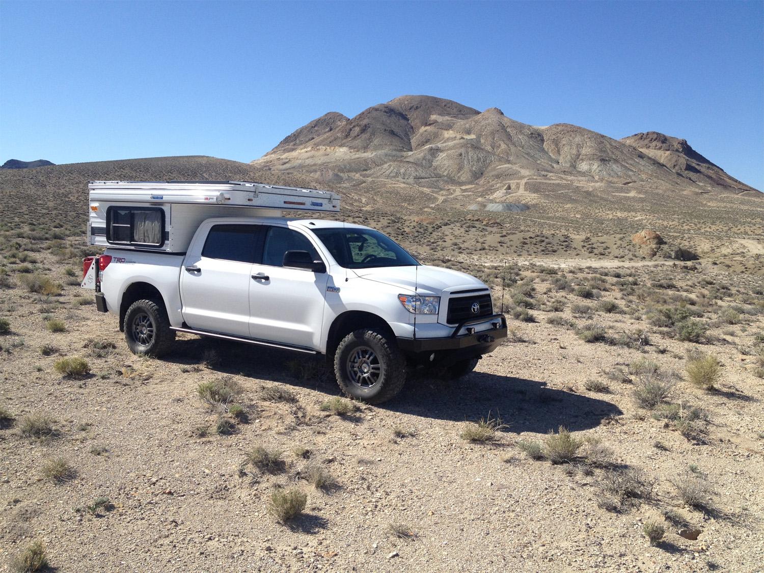 Toyota Tundra truck camper navigating desert terrain with upgraded suspension