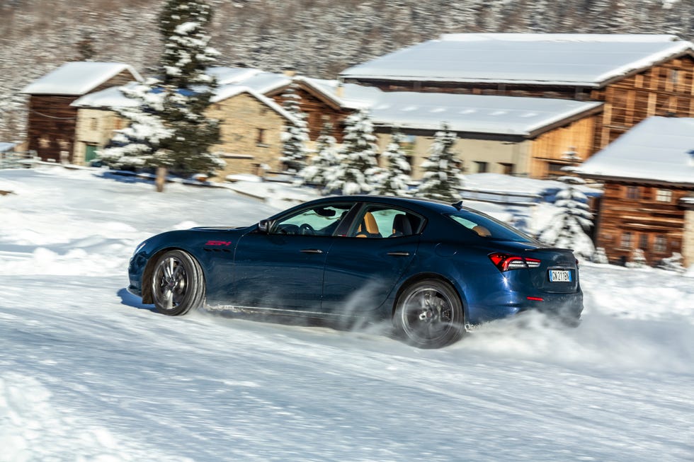 A Maserati Ghibli 334 performing high-speed maneuvers on an ice driving track.