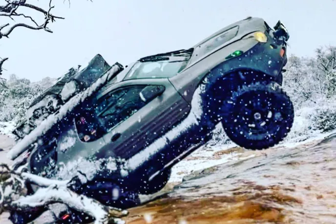 Side profile view of a modified 2001 Isuzu VehiCROSS on a dirt road.