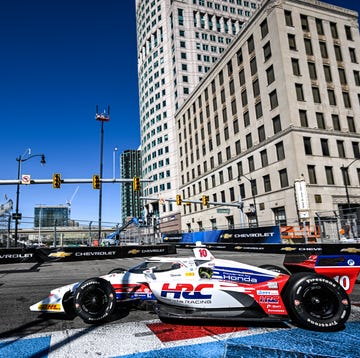IndyCar series vehicles racing through a city course.