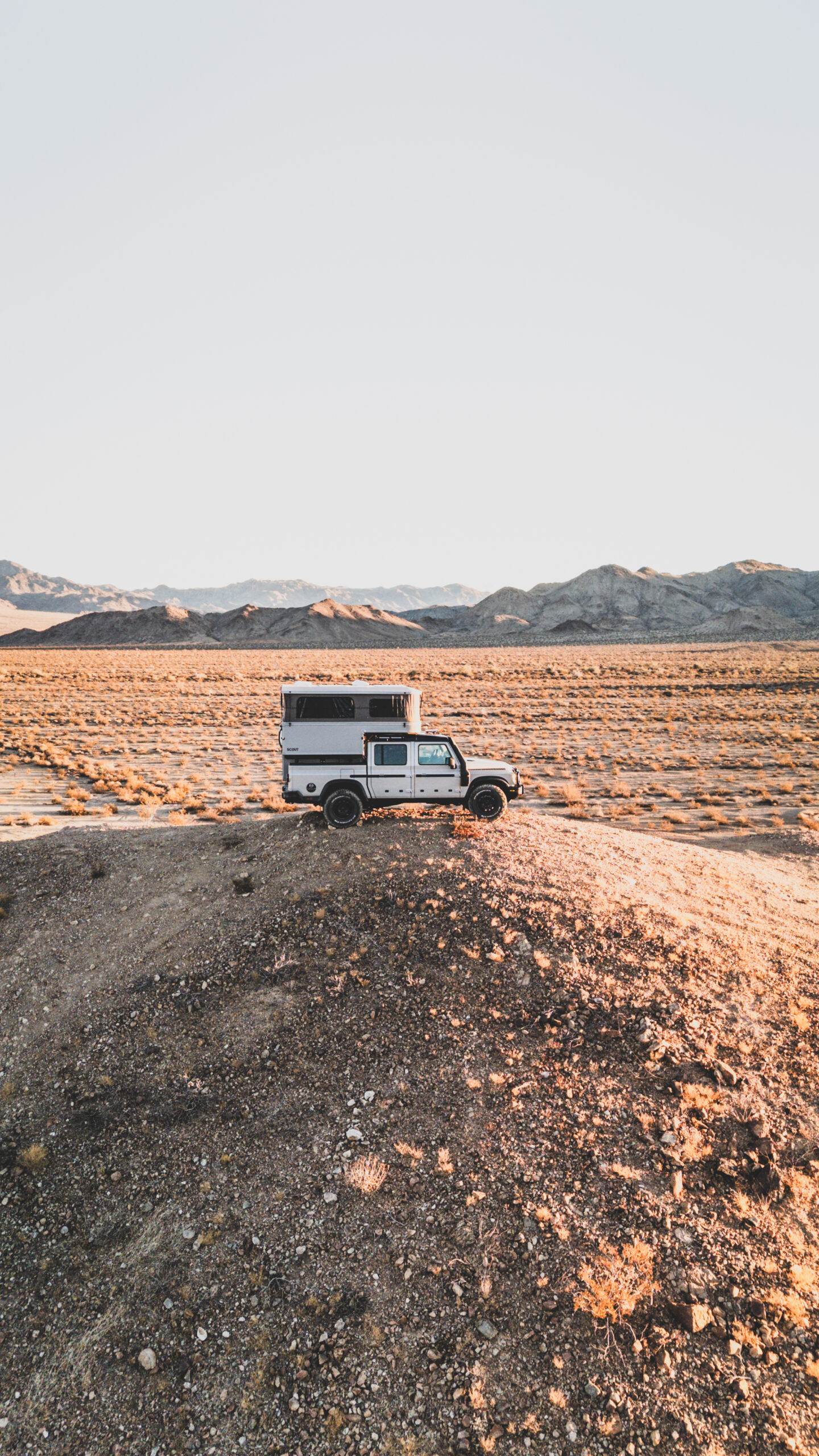 The Scout Yoho Pop-up truck camper mounted on a vehicle in a rugged mountain landscape.