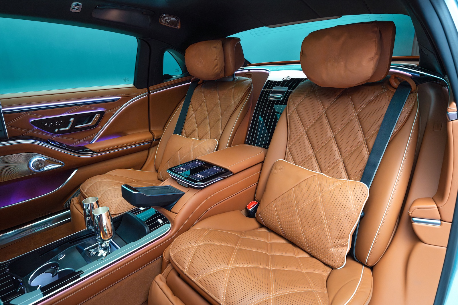 The executive rear seating area of the Maybach S-Class with entertainment screens and luxury pillows.