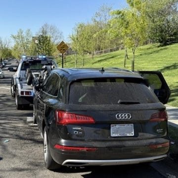 A modern vehicle towing a trailer on an open road.