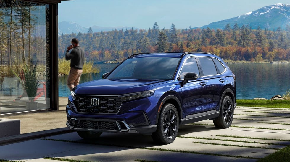 A blue 2024 Honda CR-V Hybrid parked on a residential street.