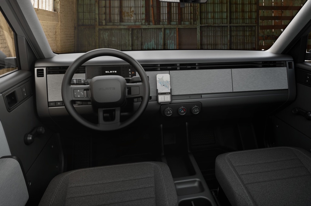 The interior dashboard of the Slate truck featuring a phone mount, basic toggle switches, and a minimalist steering wheel.