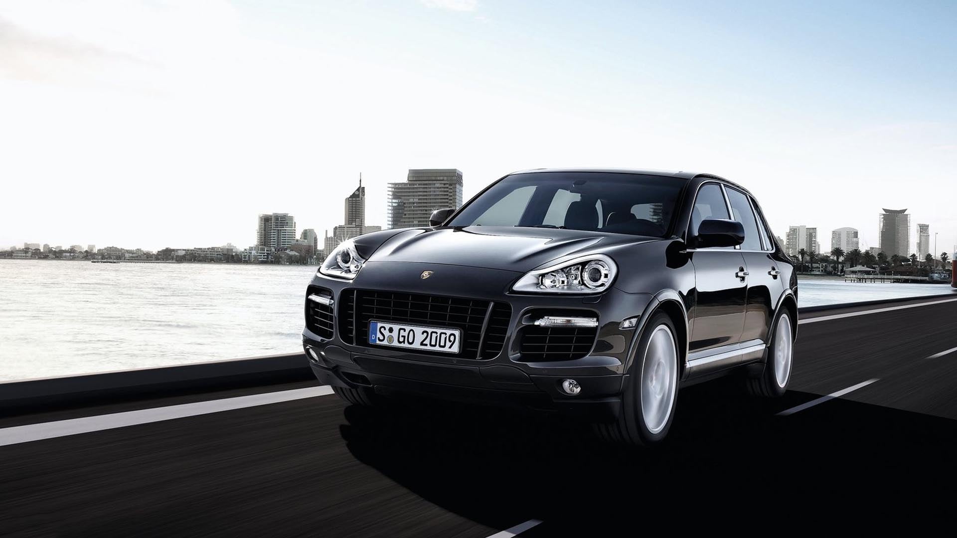 A silver 2004 Porsche Cayenne S driving through a suburban environment.