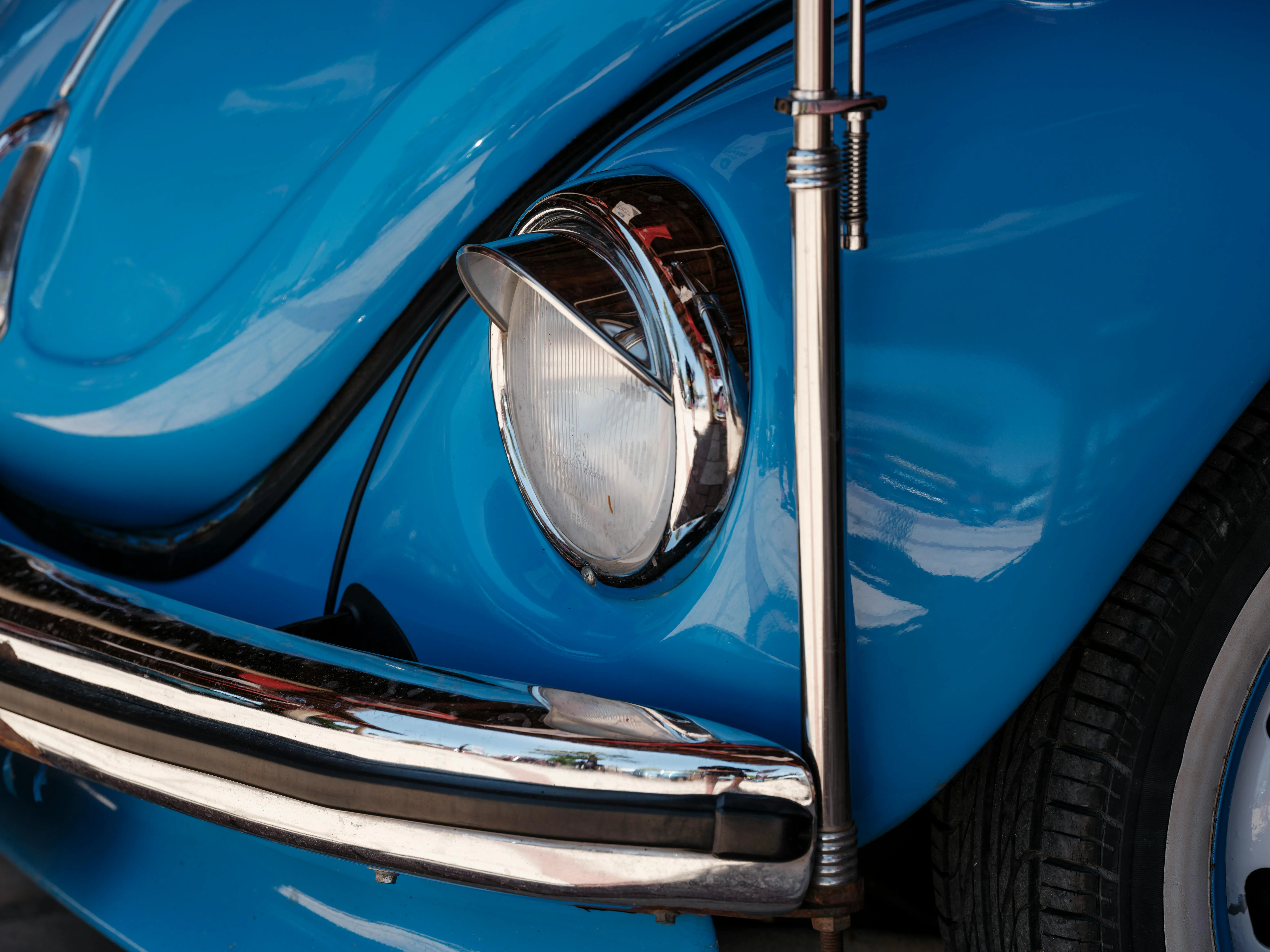 A profile view of a blue classic enthusiast car parked outdoors.