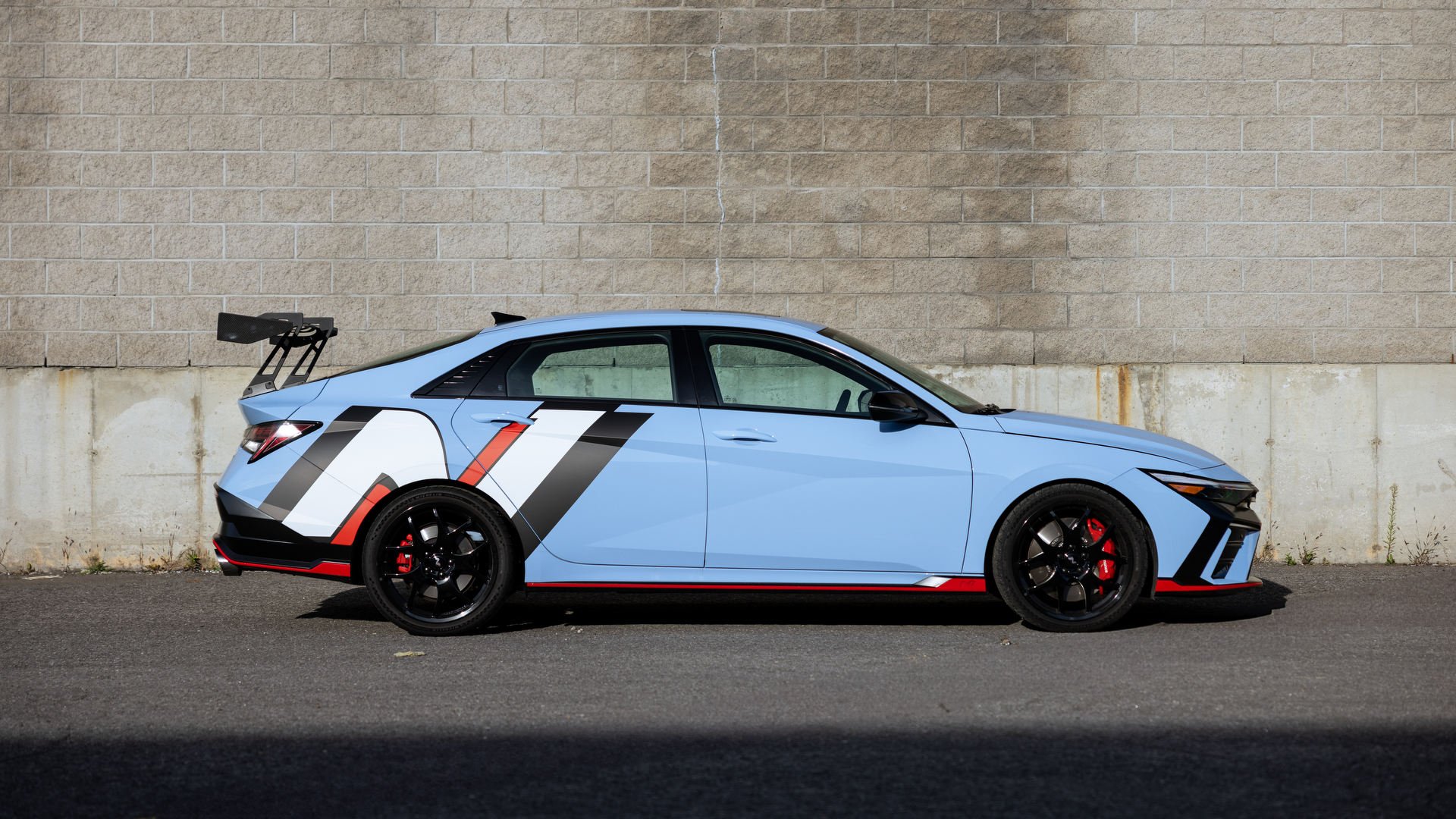 Side profile of the 2026 Hyundai Elantra N TCR Edition showing the forged alloy wheels and aerodynamic profile.