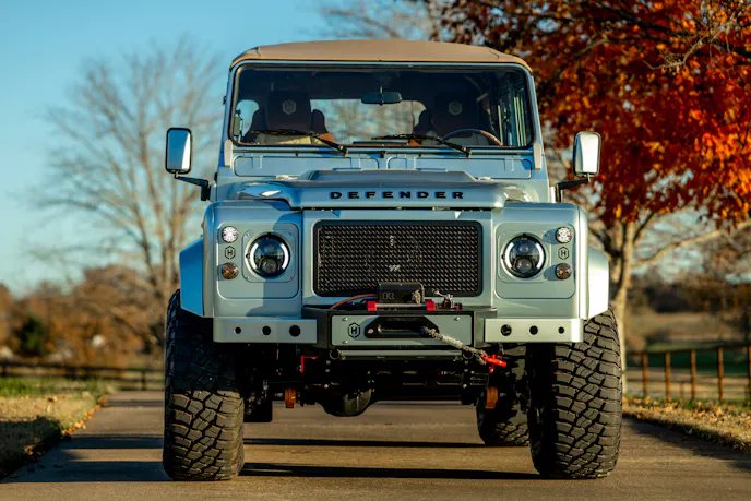 Side profile of a soft-top Willow Green Helderburg Defender 110.