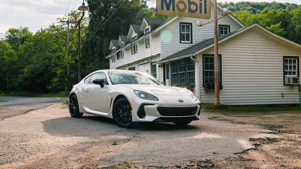 A white Subaru BRZ tS parked next to a vintage Mobil gas station pump.