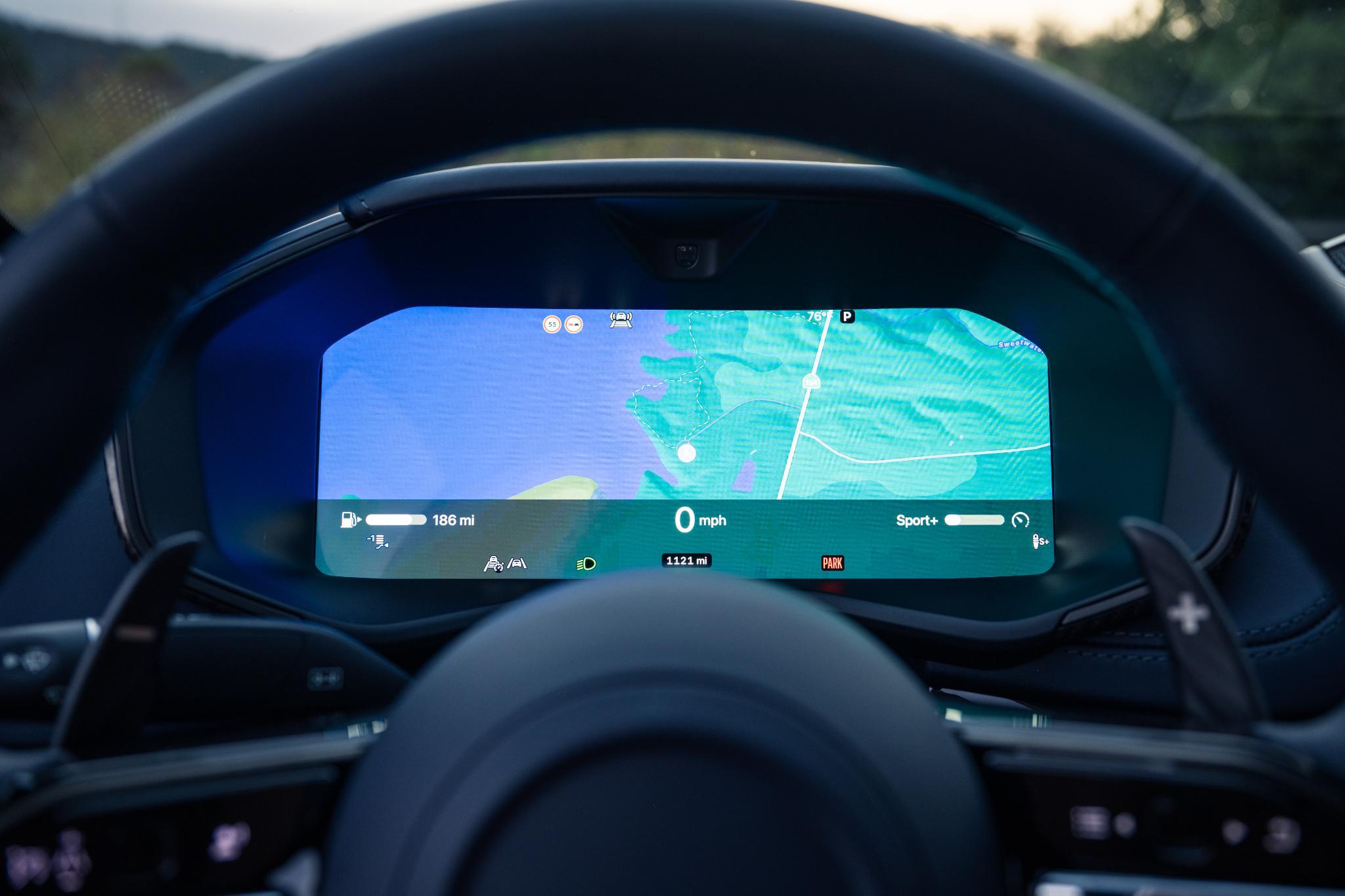 An Aston Martin DBX S driving dynamically on a winding mountain road.