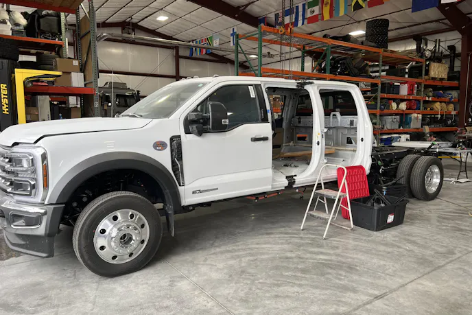 Side profile of the stretched six-door Ford F-550 chassis showing the extended frame rails.