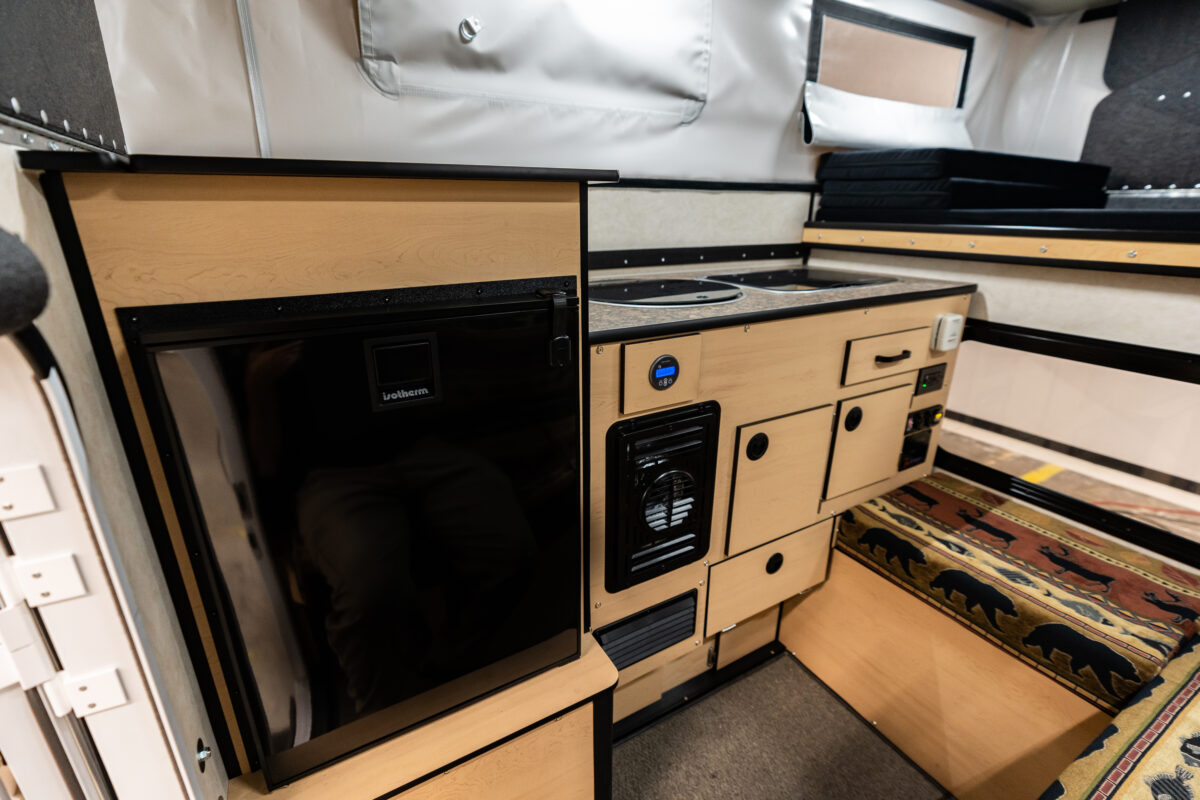 Interior view of a truck camper showing a comfortable rollover couch and living area