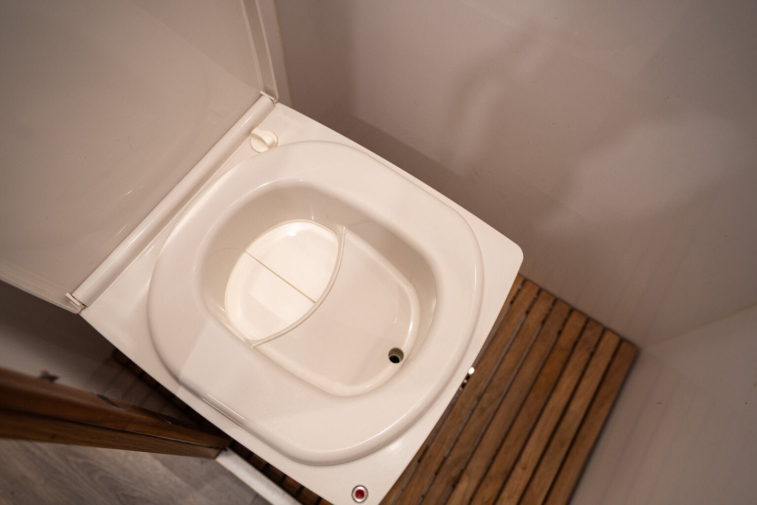 The Cuddy Lite toilet installed in a small, modern camper van bathroom area.