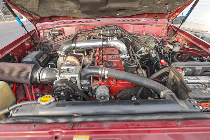 A Cummins 6BT 12-valve diesel engine installed inside a Land Cruiser engine bay.