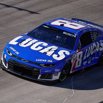 NASCAR Cup Series cars navigating pit road entry and exit during a green-flag cycle.