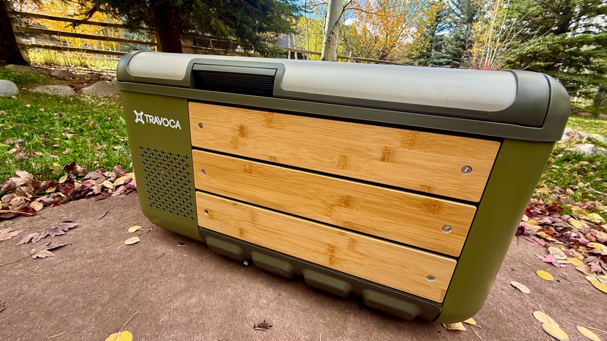 Testers evaluating different 12V portable refrigerator models in a dry, outdoor camping environment.