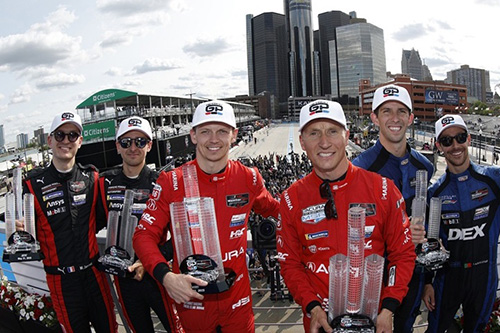 Drivers celebrating on the podium at the Detroit Sports Car Classic.