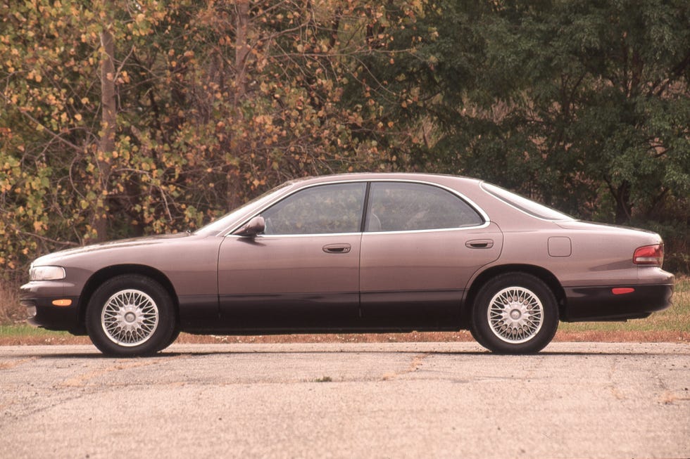 A 1992 Mazda 929 driving on a scenic road.