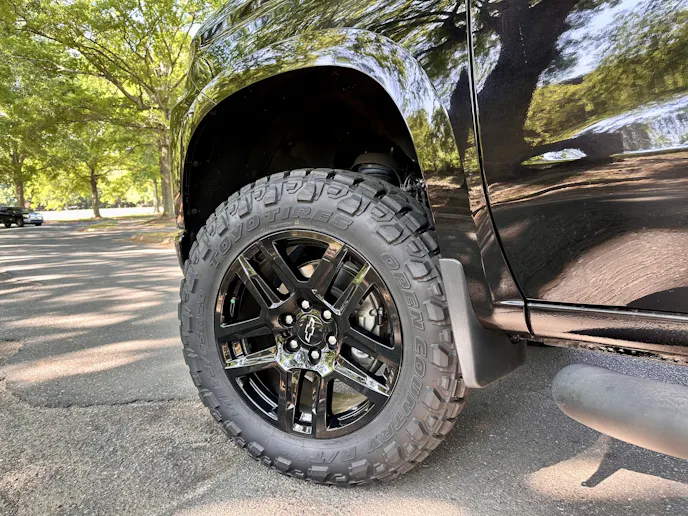 Side profile of a truck tire showing the transition between aggressive shoulder lugs and all-terrain center blocks.