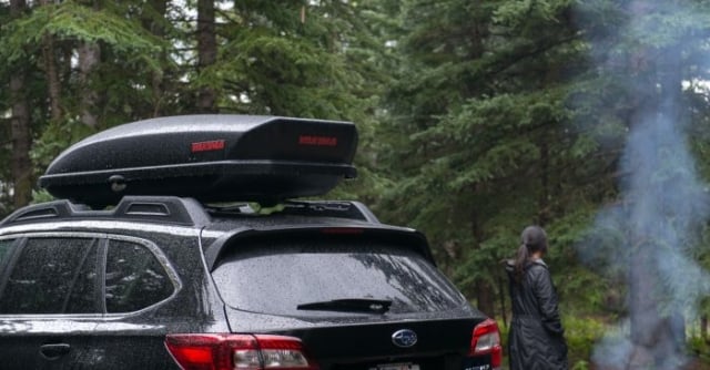Wide shot of a white Subaru Outback equipped with a Yakima SkyBox 16.