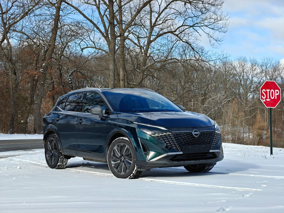 A white Nissan Qashqai e-Power parked in a modern urban environment.