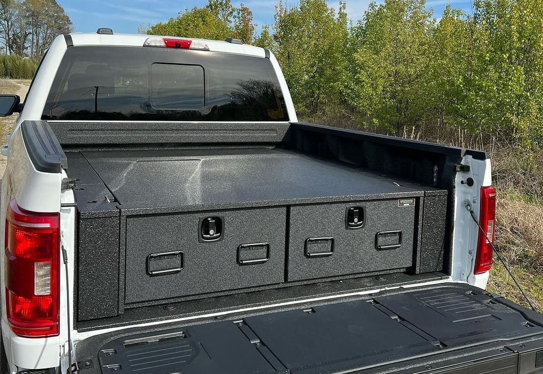 Close-up of a reinforced truck bed toolbox with a locking mechanism.