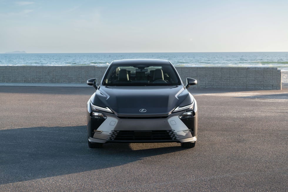 Exterior view of the silver 2026 Lexus ES 350h hybrid on a coastal road.
