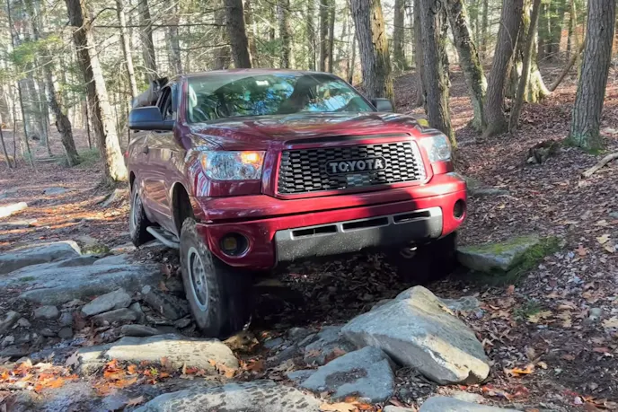 A wide shot of the fully modified white Tundra Regular Cab on a trail.
