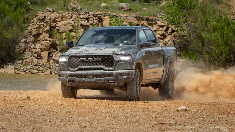 Full side profile of the 2026 Ram Rebel X parked on a gravel path.