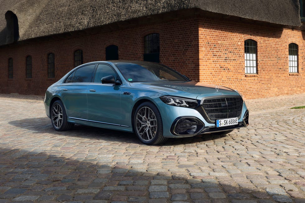 Side profile of a 2027 Mercedes-Benz S580e 4MATIC in Verde Silver Metallic parked by the coast.