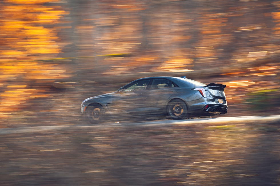 A Cadillac CT4-V Blackwing driving dynamically on a winding road.
