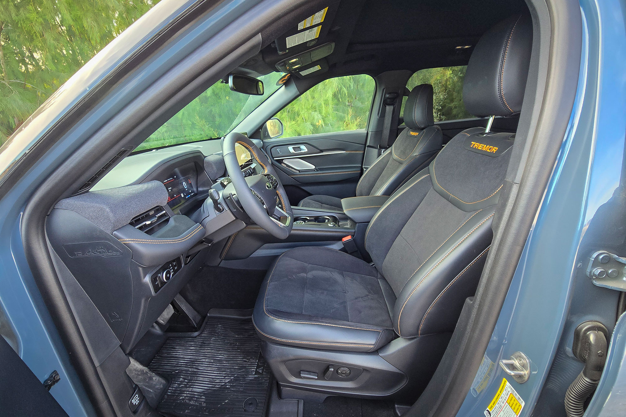 Interior view of the front seats featuring 'Tremor' embroidery and orange stitching.